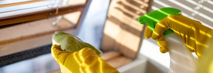 Fenster mit Lappen und Reiniger putzen